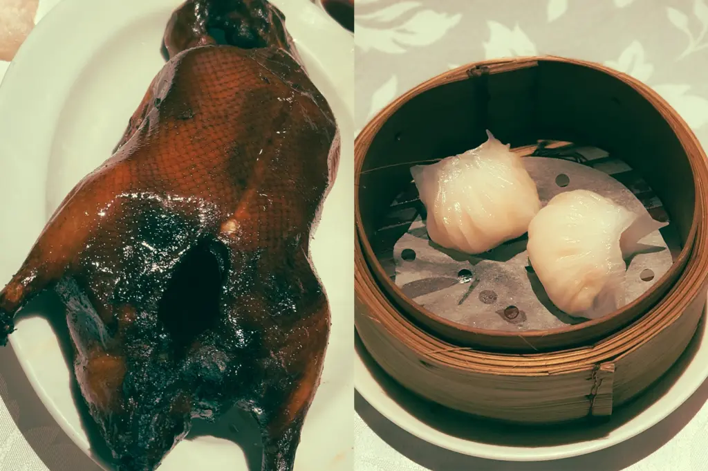 Left: Close-up, top-down angle of a whole roasted Peking duck on a white oval plate, glossy dark-brown crispy skin reflecting warm indoor lighting, textured lacquered surface with visible carving lines, set against a neutral tablecloth in a refined Cantonese restaurant setting; Right: Eye-level, close-up of two translucent har gow shrimp dumplings inside a round bamboo steamer lined with perforated parchment paper, soft diffused light highlighting the delicate pleated wrappers and moist texture, placed on a white plate in an elegant dim sum dining environment.